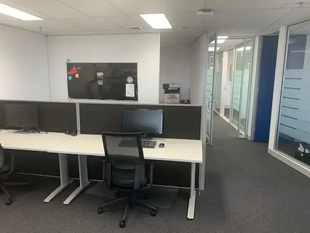 Open-plan desks on Level 9 with glass-walled private offices along the side